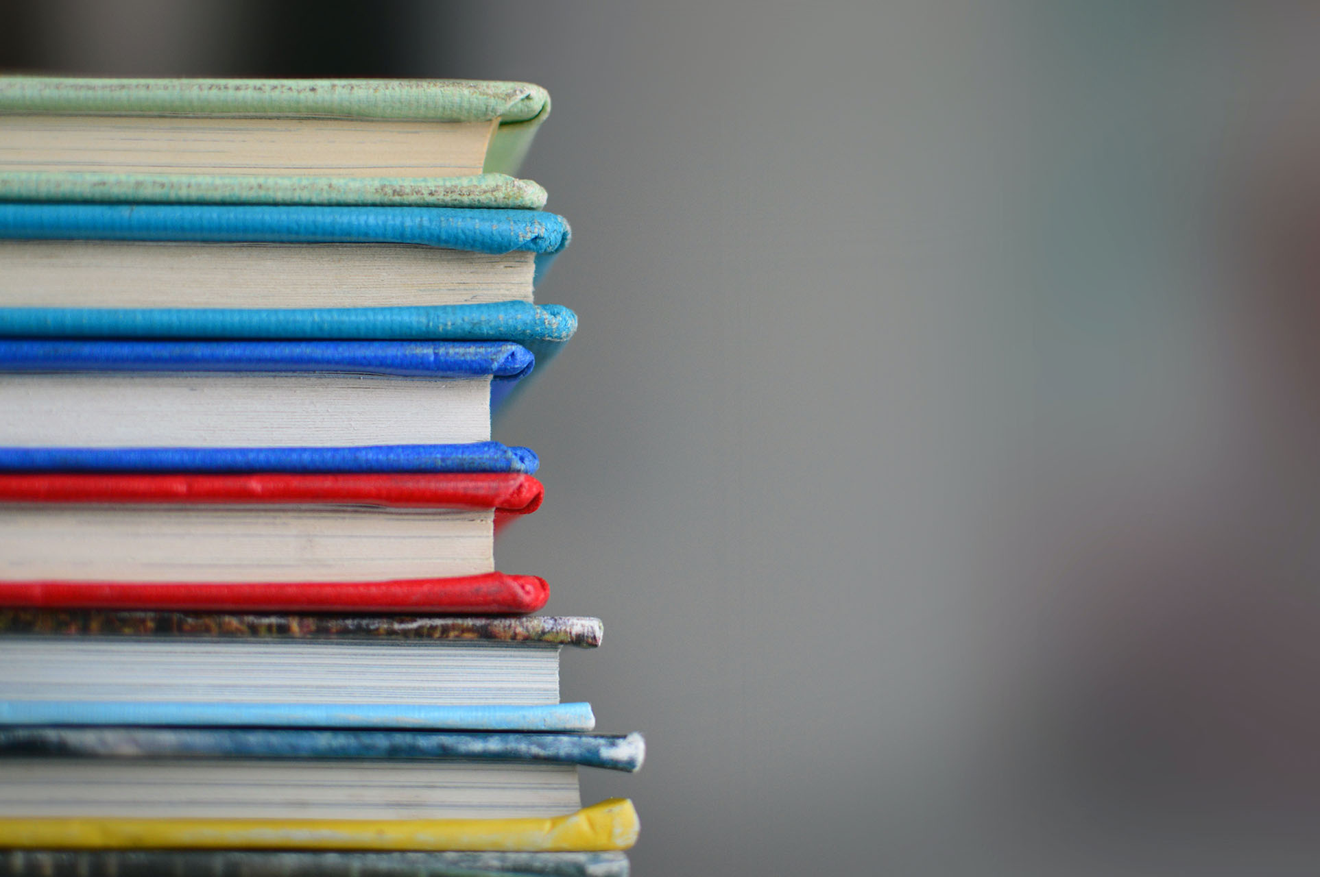 A pile of hardback books. Photo by Kimberly Farmer on Unsplash.